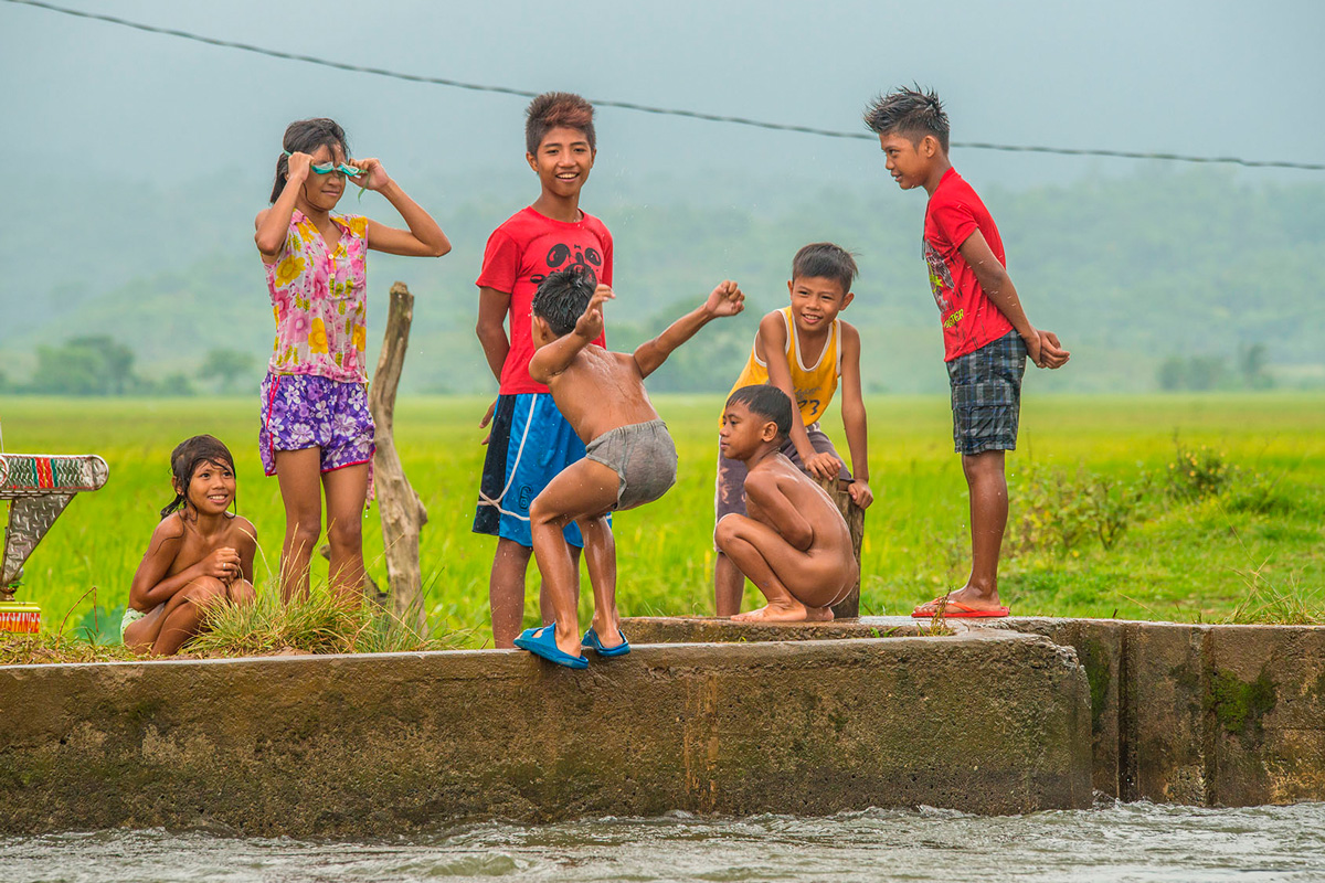 Philippines, children playing at water channel