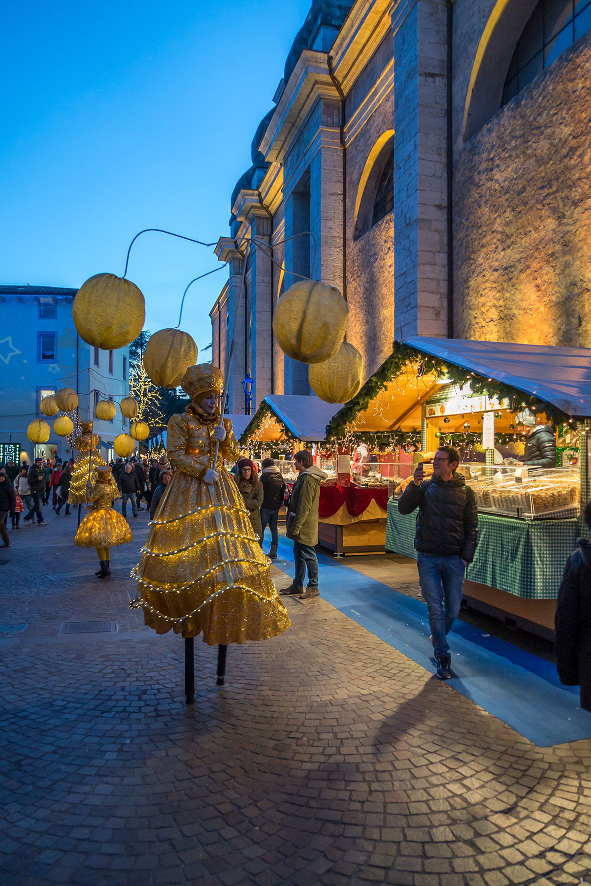 Christmas market in Arco with street performers in stilts and lanterns
