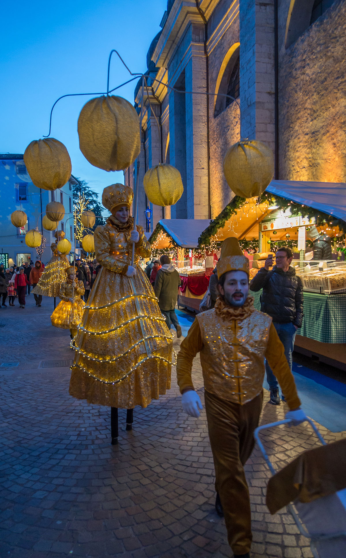 Weihnachtsmarkt in Arco mit Stelzen Läufern und Lampions